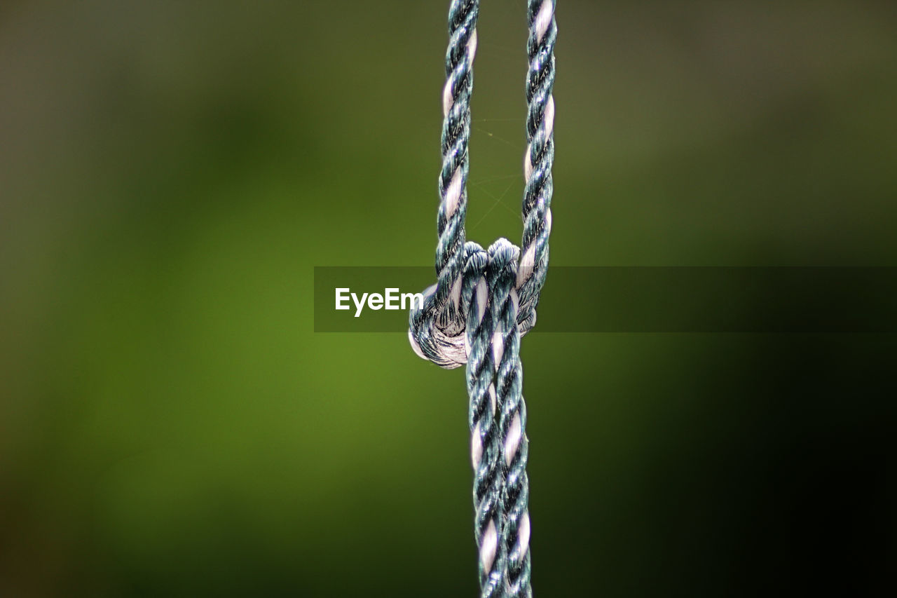 Close-up of rope tied up on metal chain