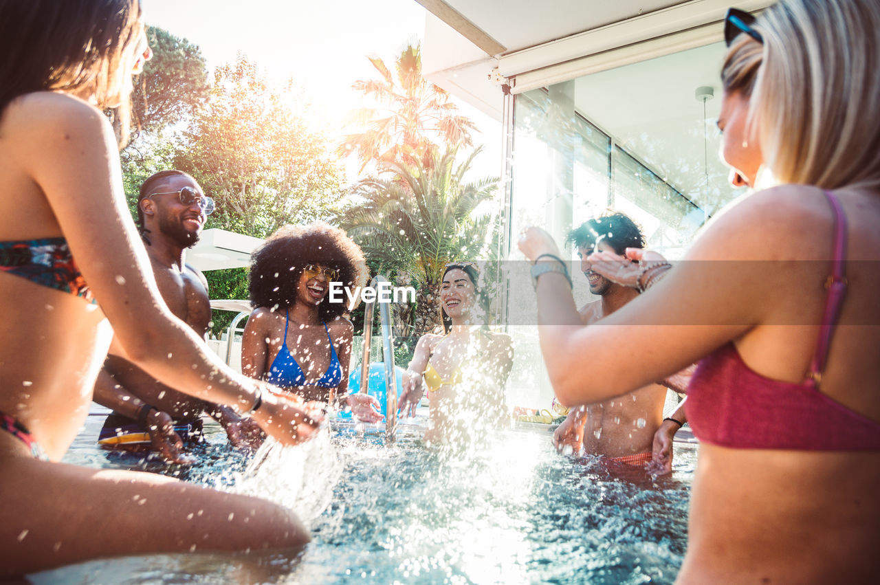 Friends enjoying in swimming pool at party