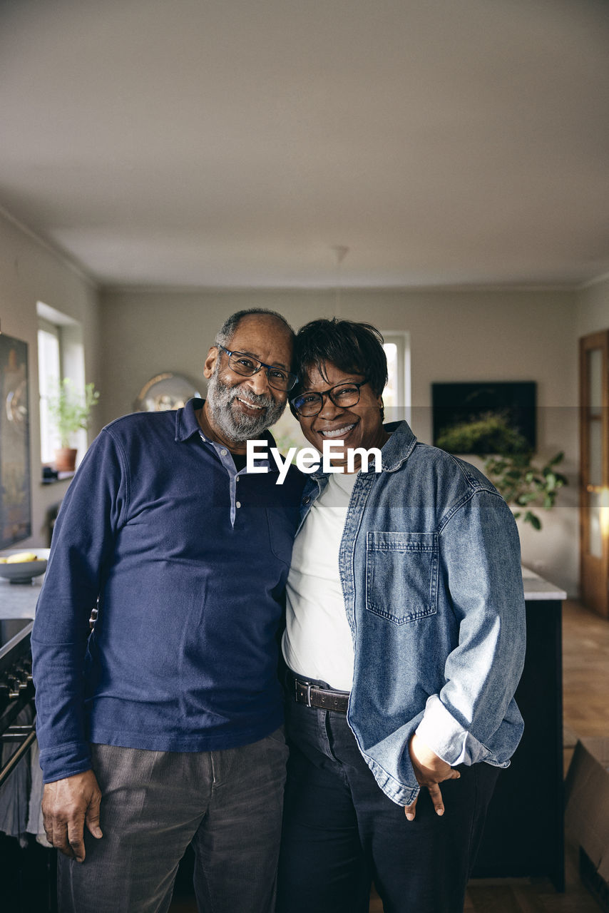 Portrait of smiling senior couple standing with each other at home