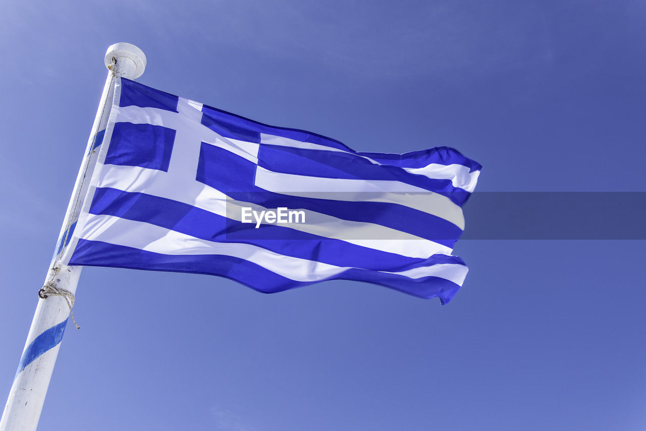 Santorini, greece, may 3, 2024. greek flag on the path between fira and oia