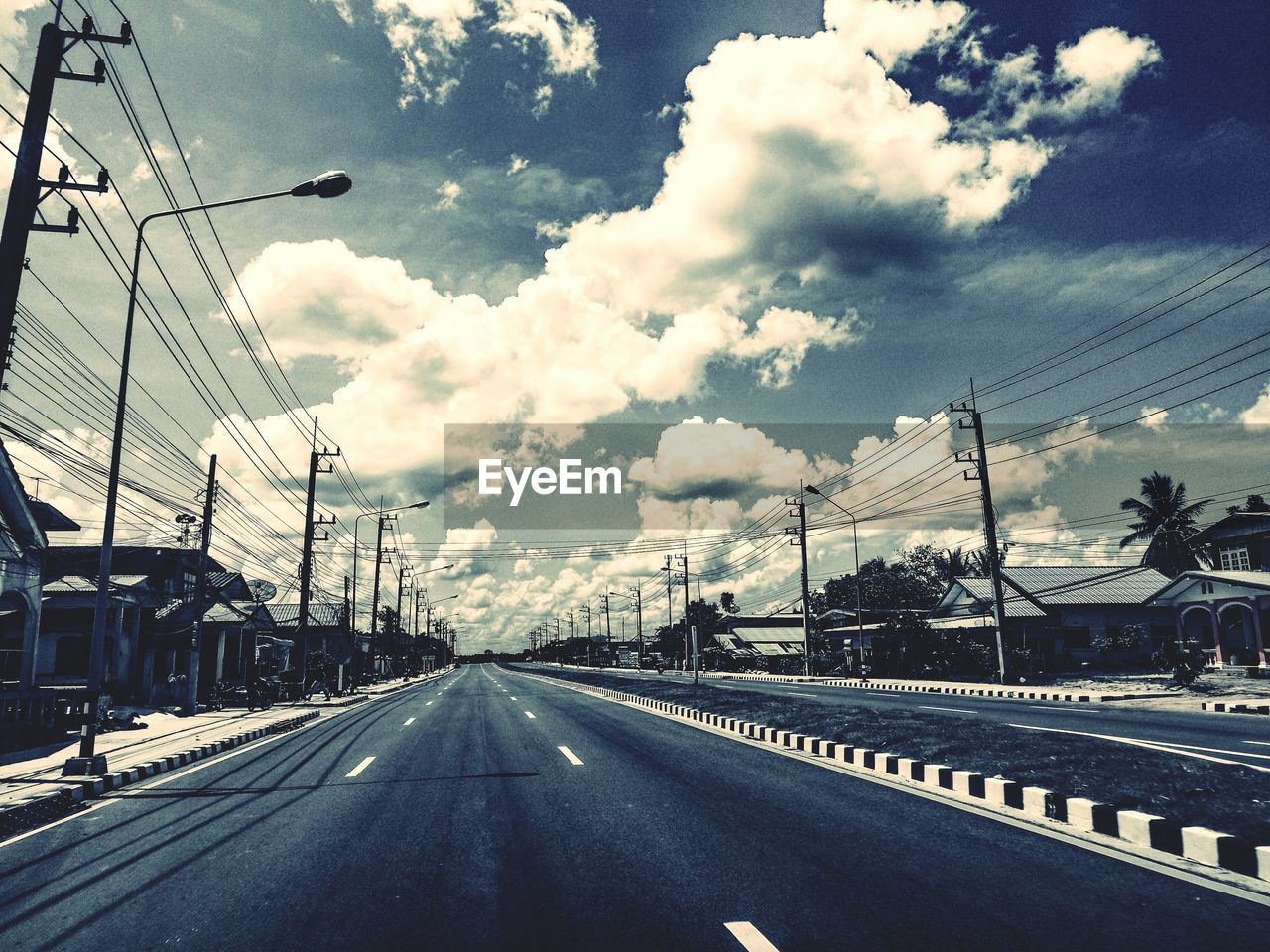 Empty road against cloudy sky