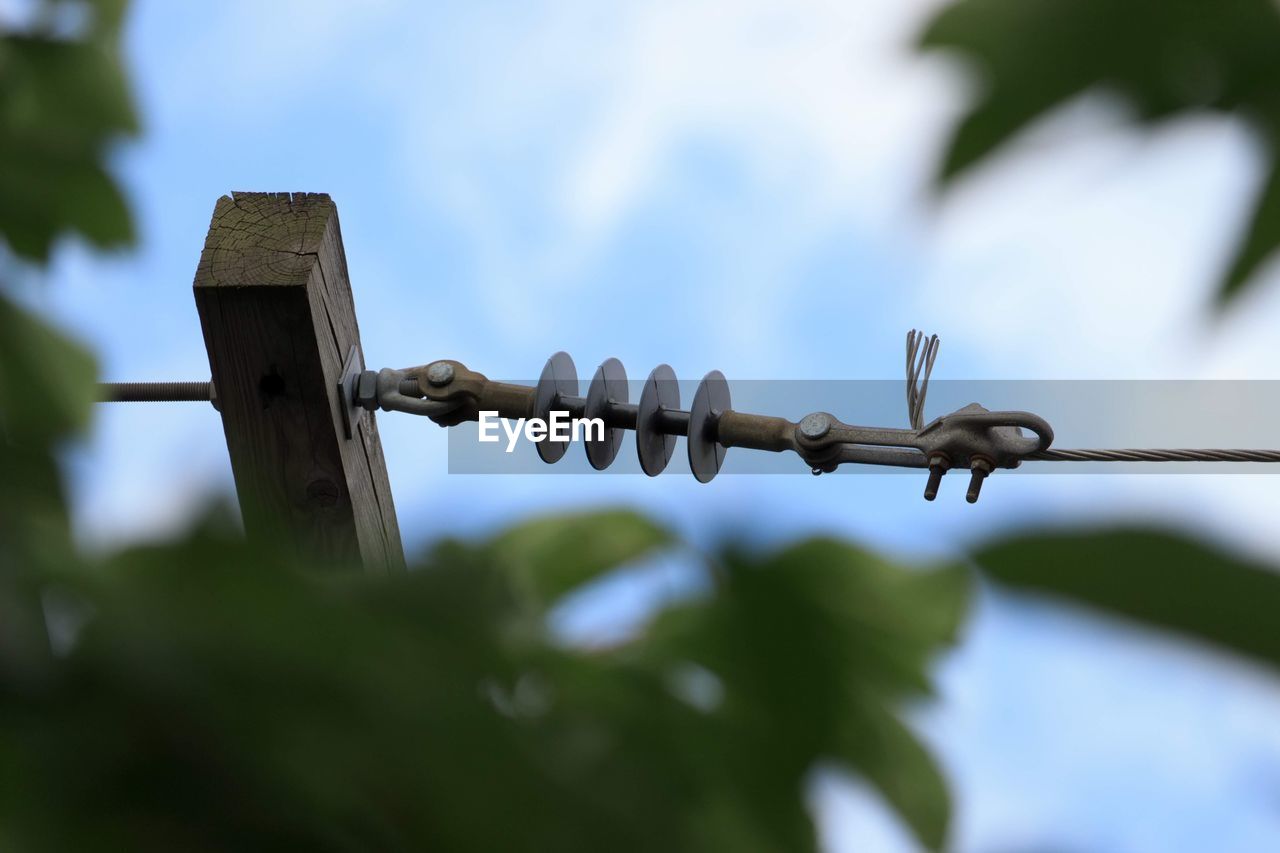 LOW ANGLE VIEW OF BARBED WIRE ON FENCE AGAINST SKY