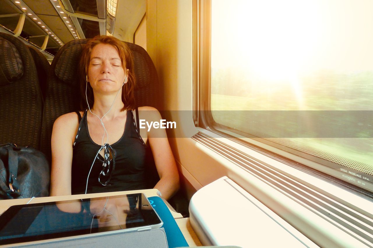 Woman listening music while sitting in train