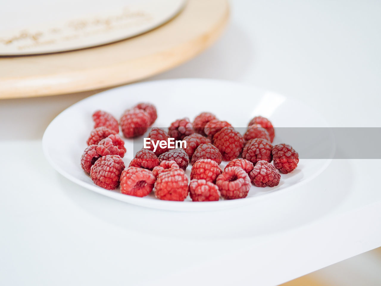 Frozen raspberries on a white plate