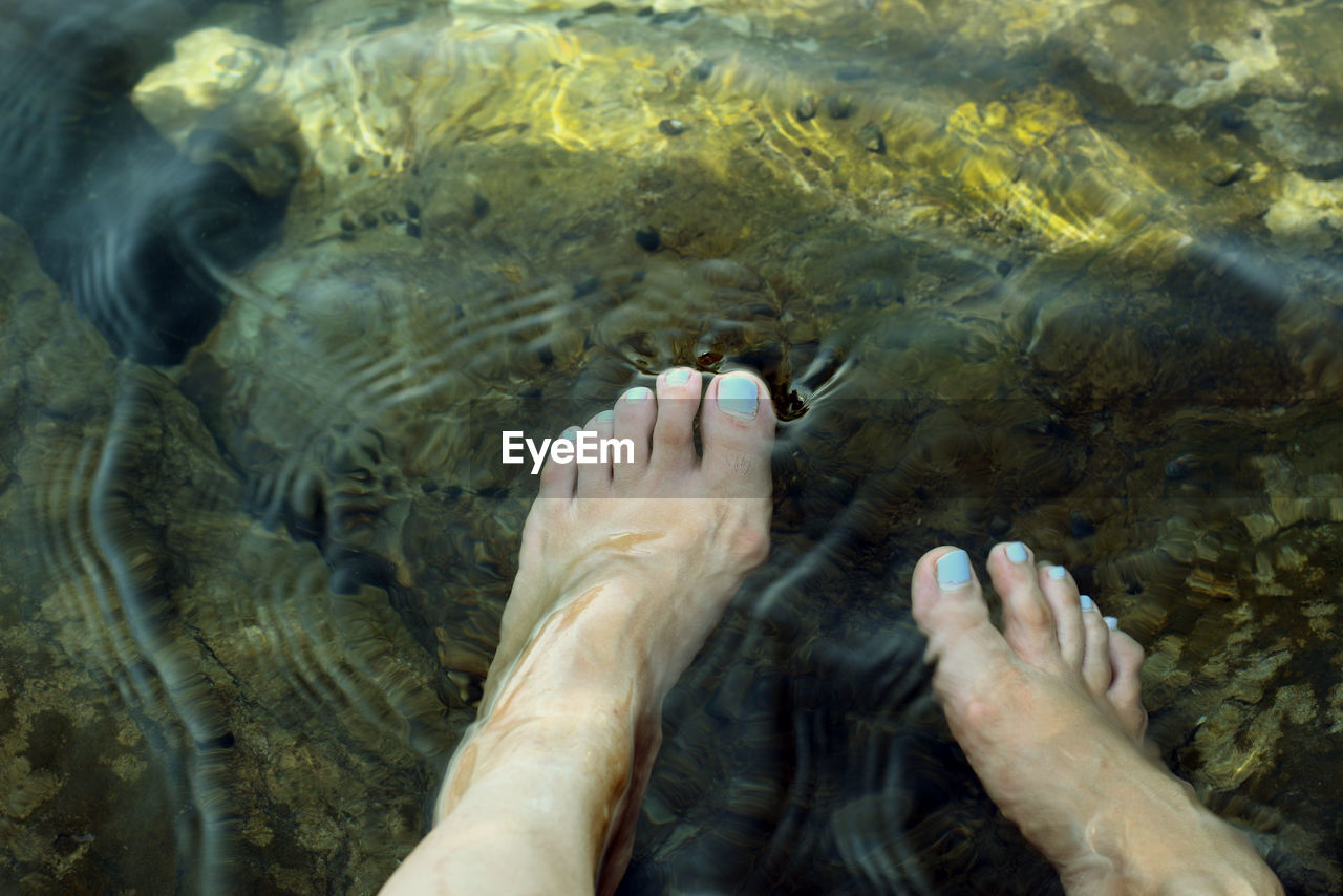 Low section of woman legs in water