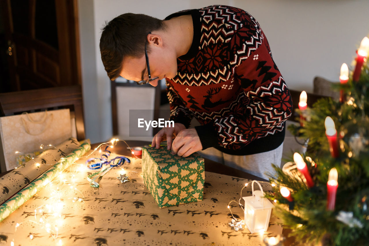 Young man packs christmas presents for friends and family