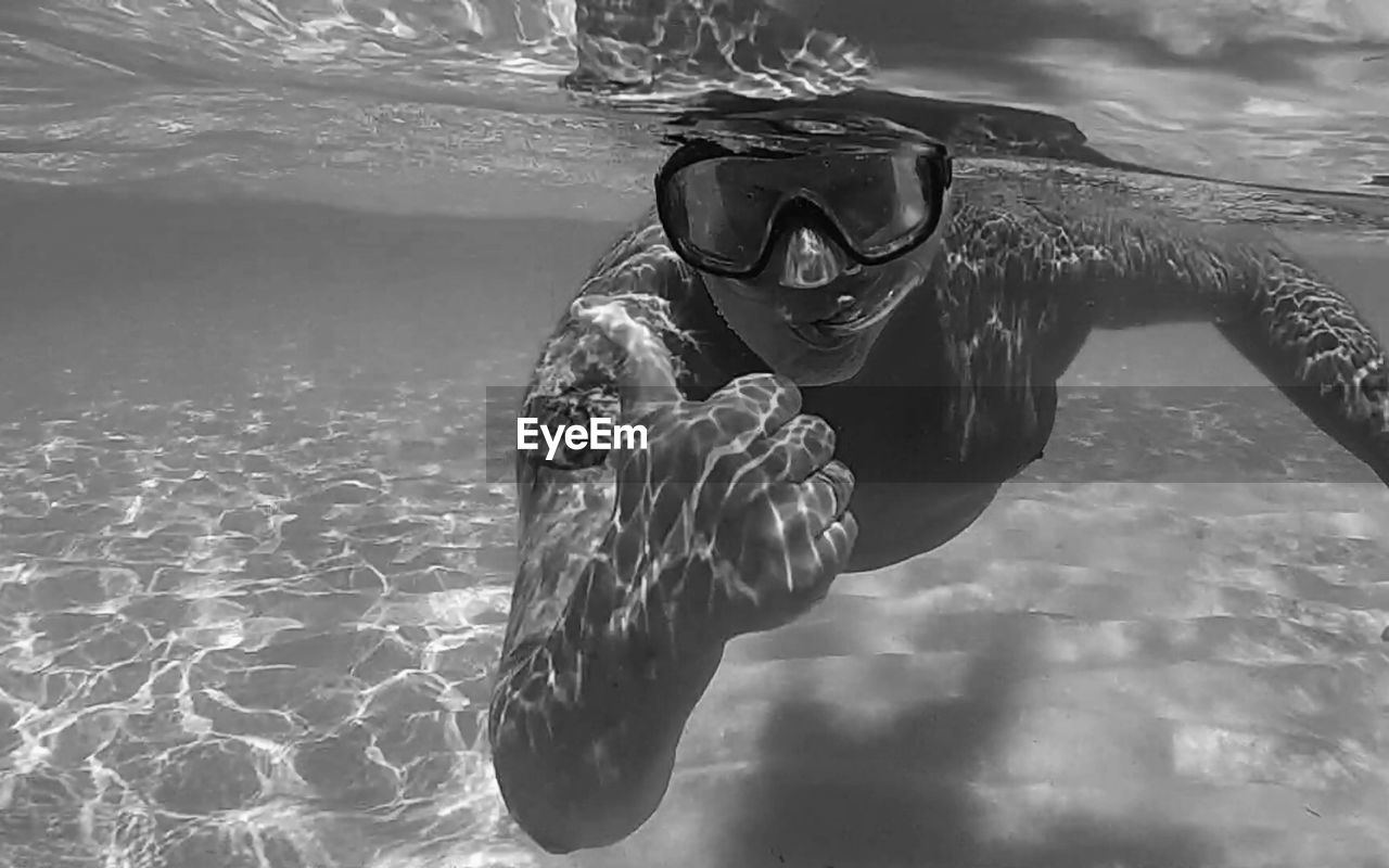 PORTRAIT OF WOMAN SWIMMING IN POOL