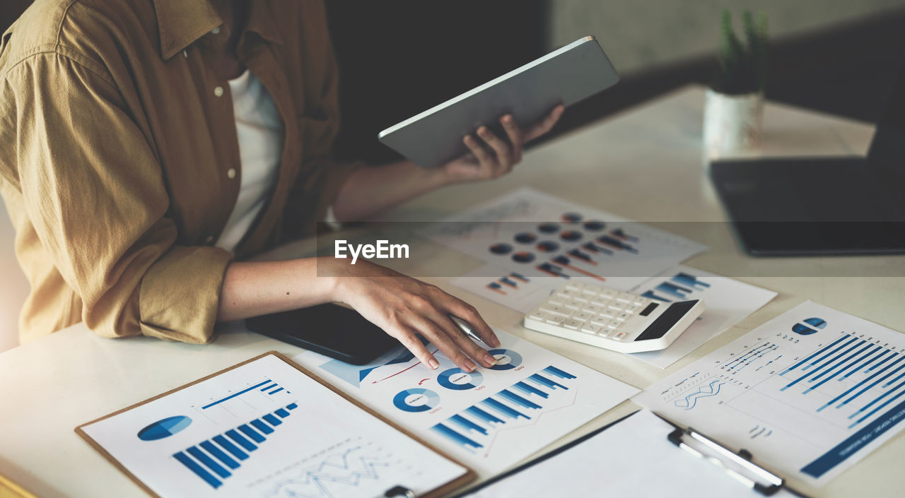 Midsection of businesswoman working on table