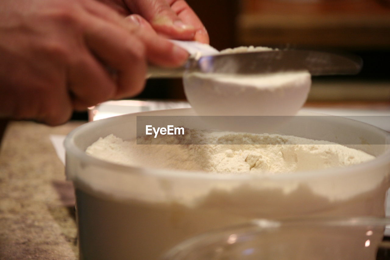 Close-up of hand measuring flour