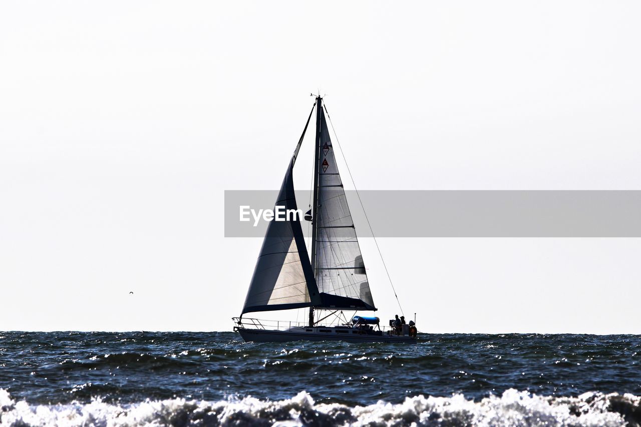 Sailboat on sea against clear sky