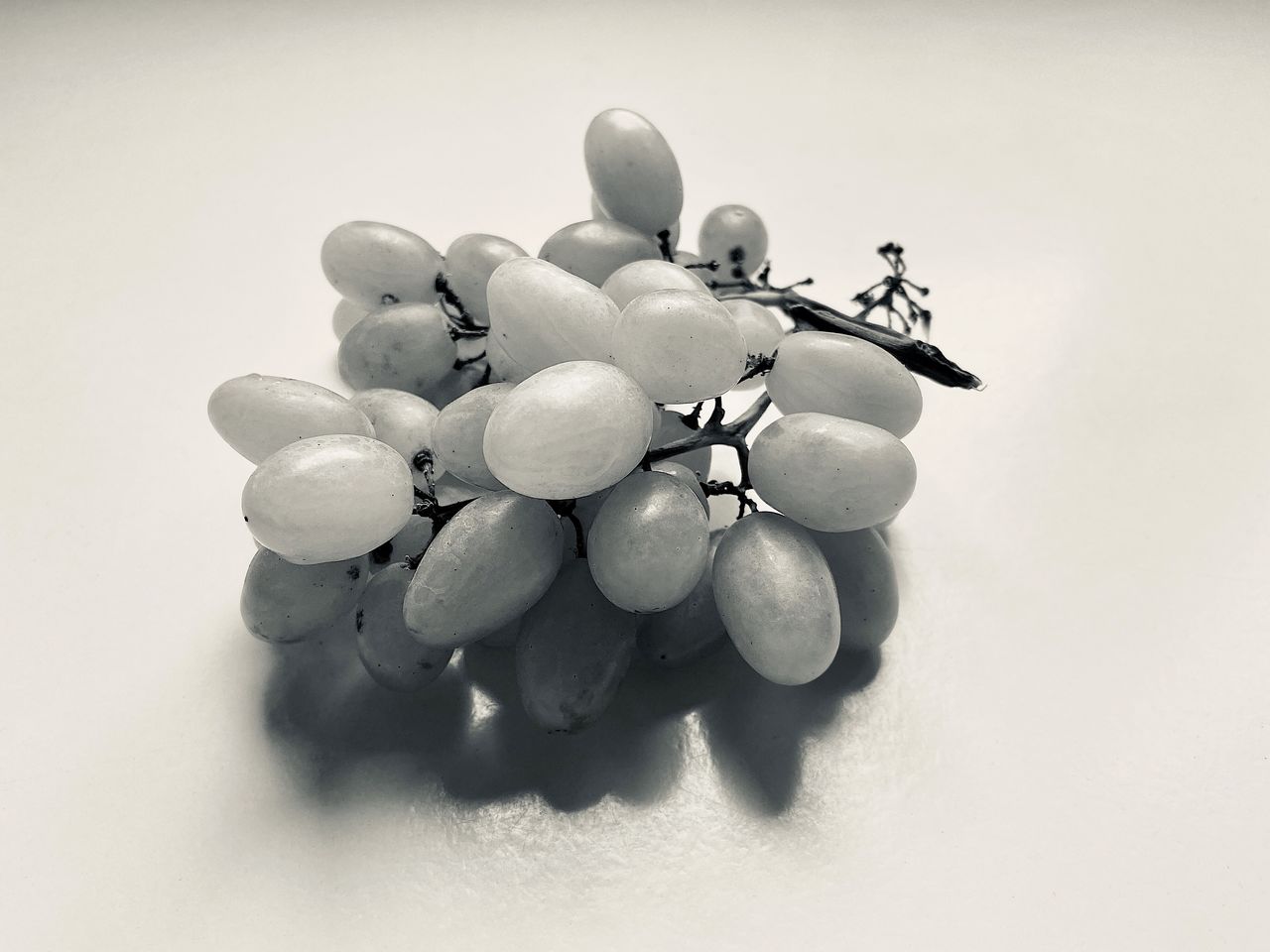 CLOSE-UP OF GRAPES ON WHITE BACKGROUND