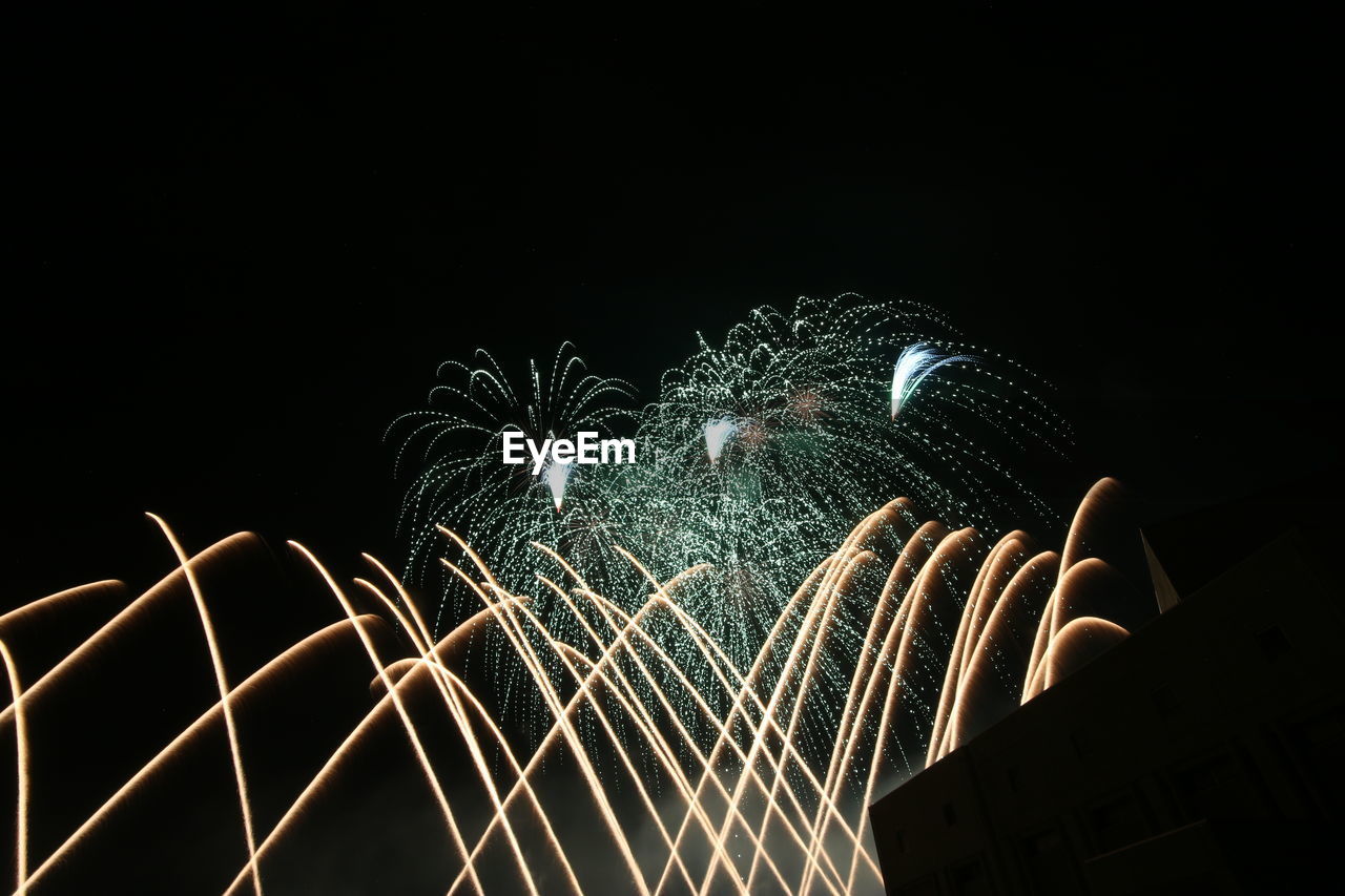 Low angle view of firework display against sky at night