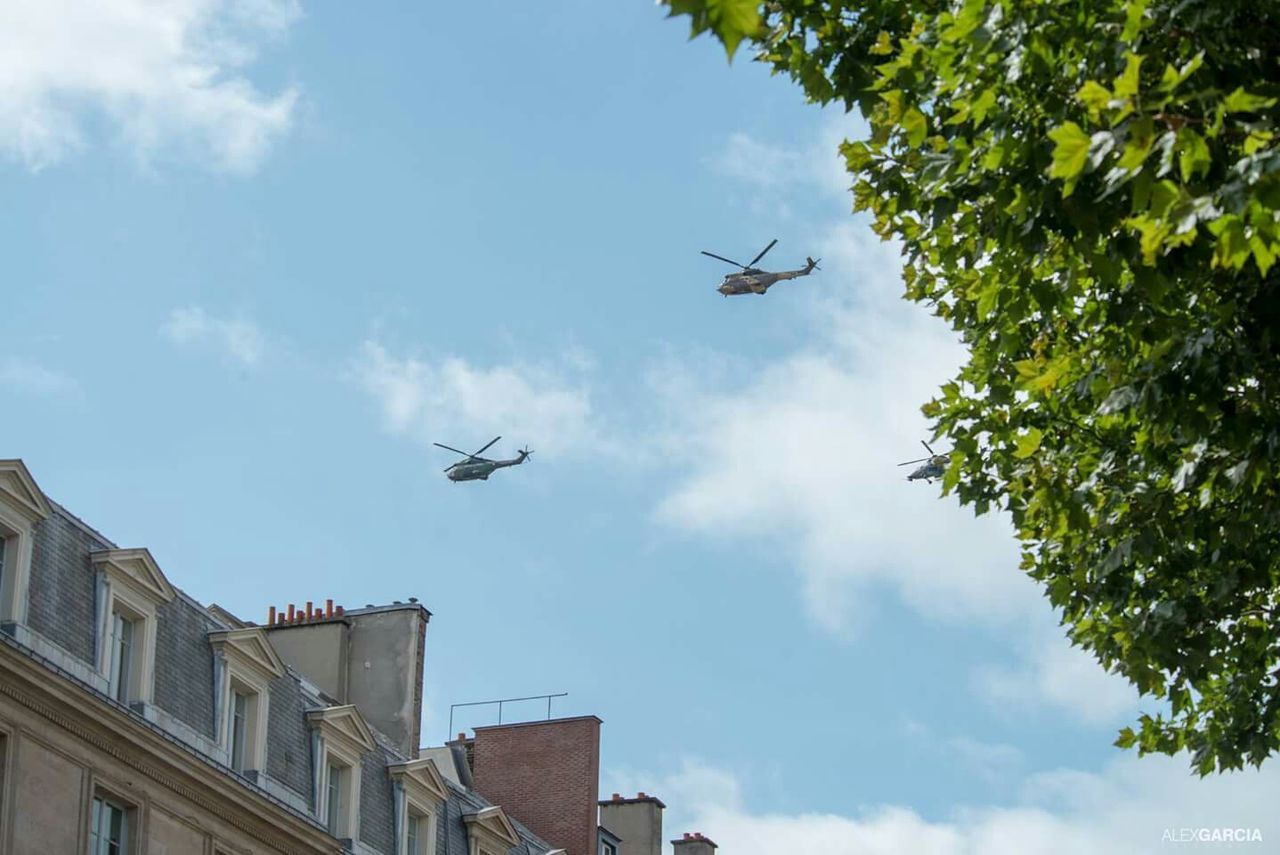 Low angle view of military helicopters flying over residential building