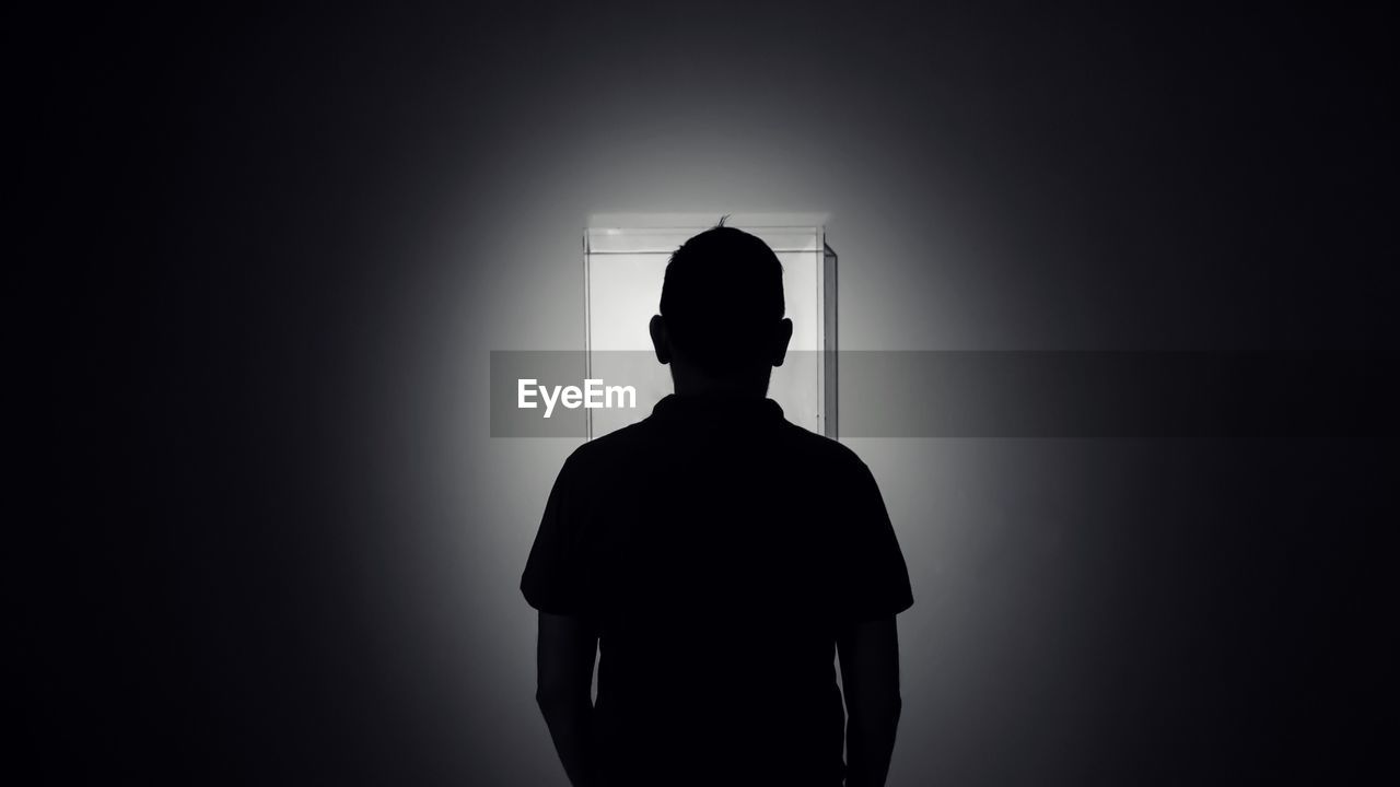 Silhouette man standing in darkroom