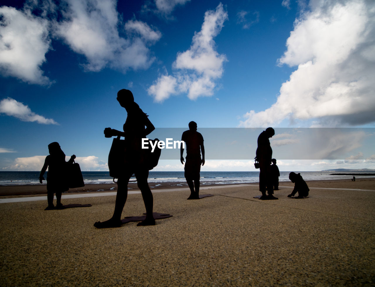 Silhouette people standing on beach