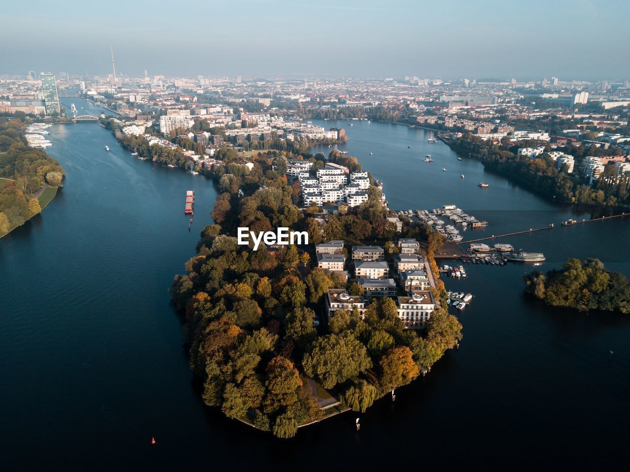 Aerial view of river amidst cityscape against sky