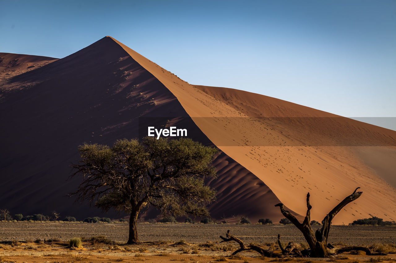 Scenic view of desert against clear blue sky