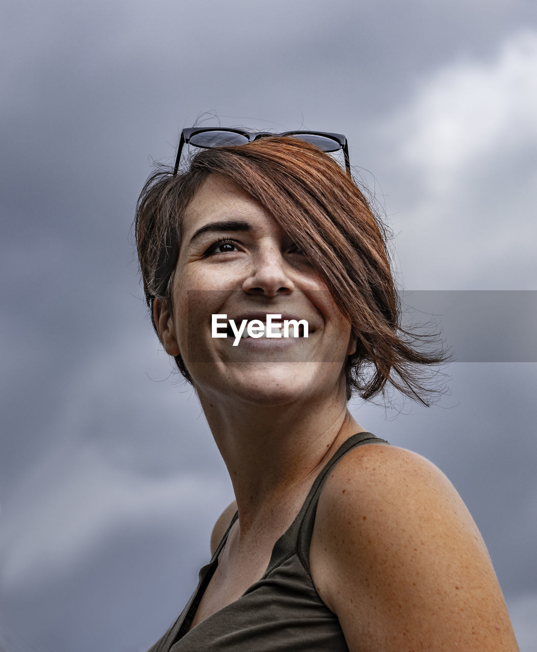 PORTRAIT OF HAPPY WOMAN AGAINST SKY