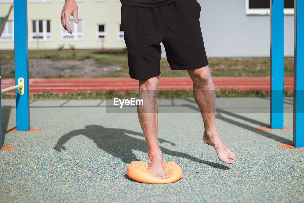 Professional athlete strengthens his ankle on a special orange air-filled lens