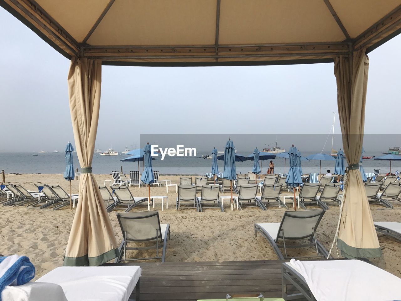 EMPTY CHAIRS AND TABLES AT BEACH