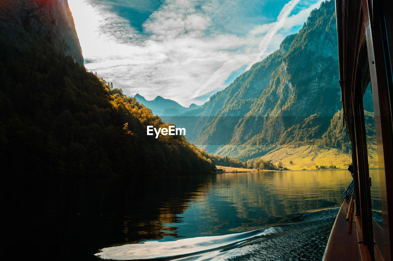 Scenic view of lake and mountains against cloudy sky