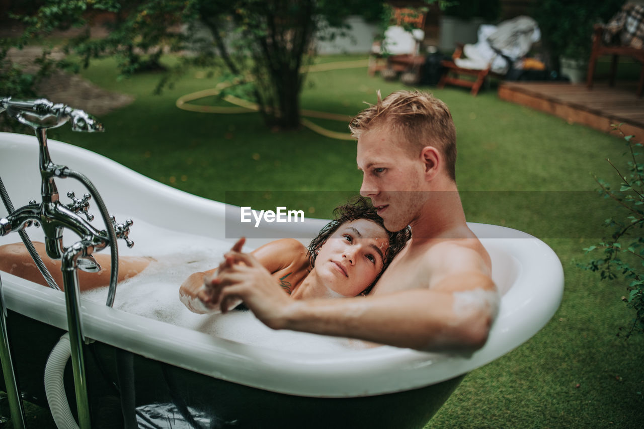 High angle view of man and woman lying down in water