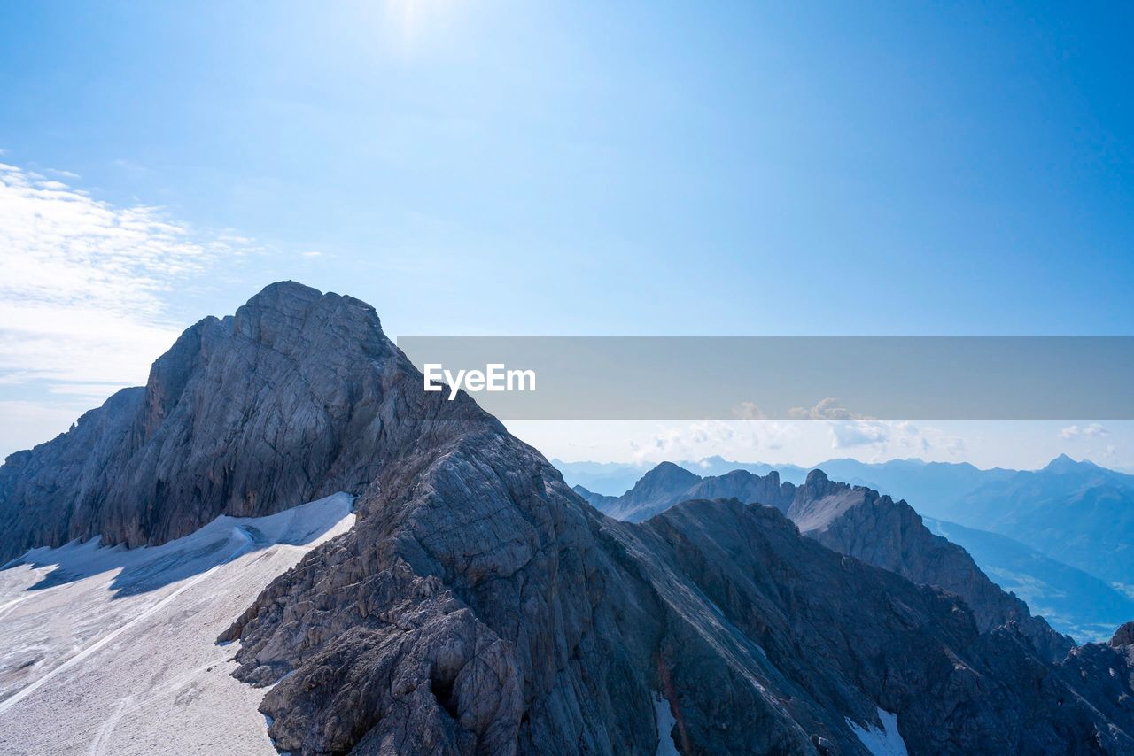 Scenic view of mountains against blue sky