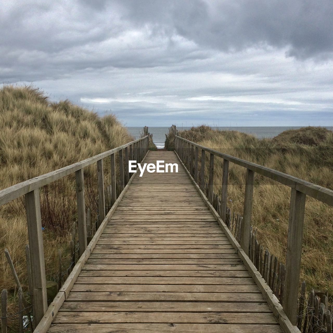 FOOTBRIDGE AMIDST SEA AGAINST SKY