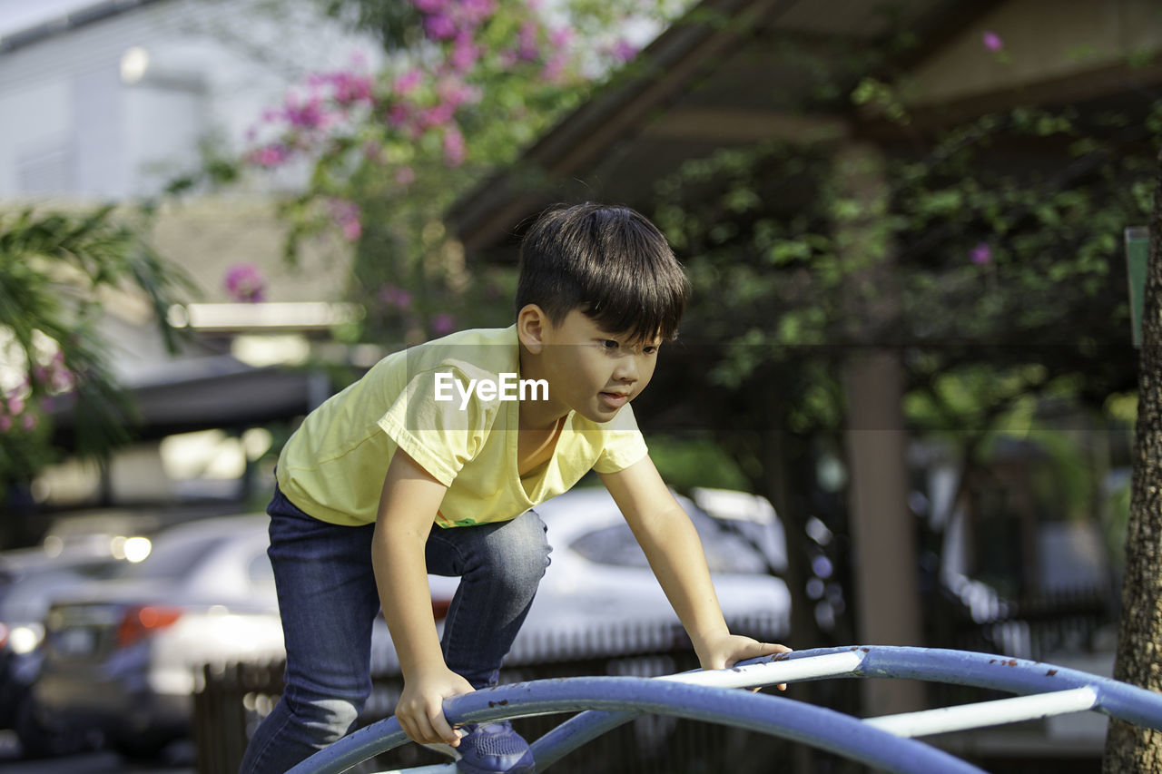 Boy climbing on monkey bars in playground