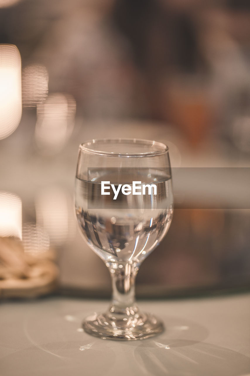 CLOSE-UP OF GLASS OF WINE ON TABLE