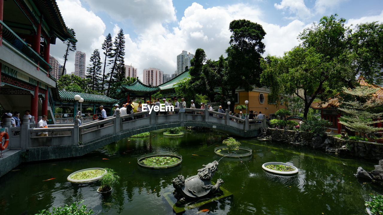 VIEW OF BRIDGE OVER LAKE IN CITY AGAINST SKY