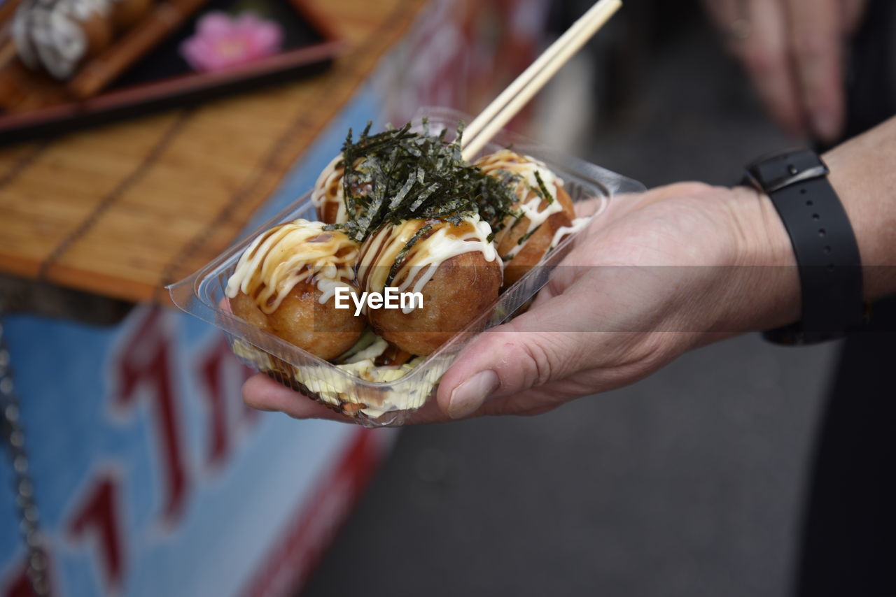 CLOSE-UP OF HAND HOLDING BREAD