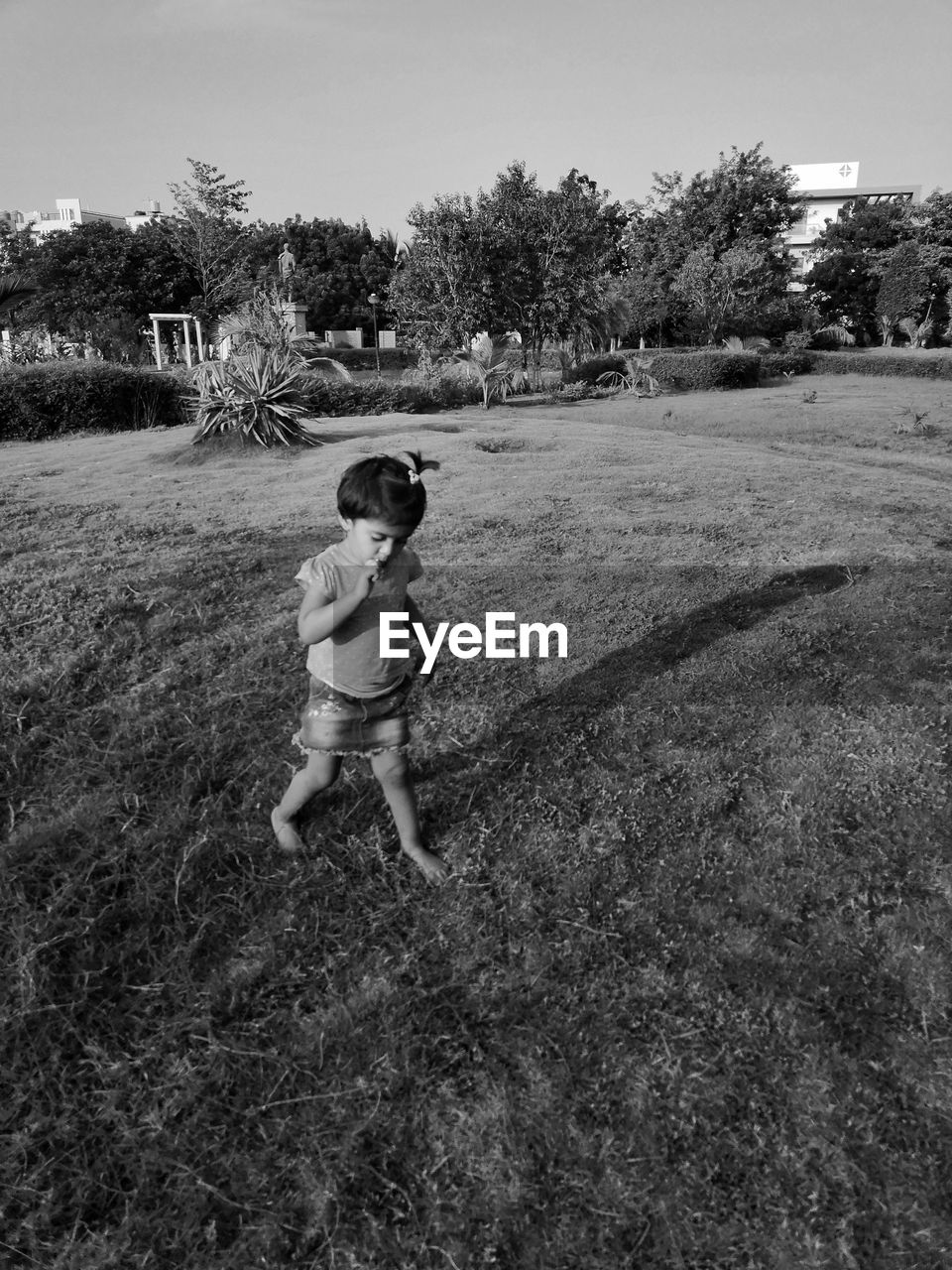 GIRL WALKING ON GRASSY FIELD