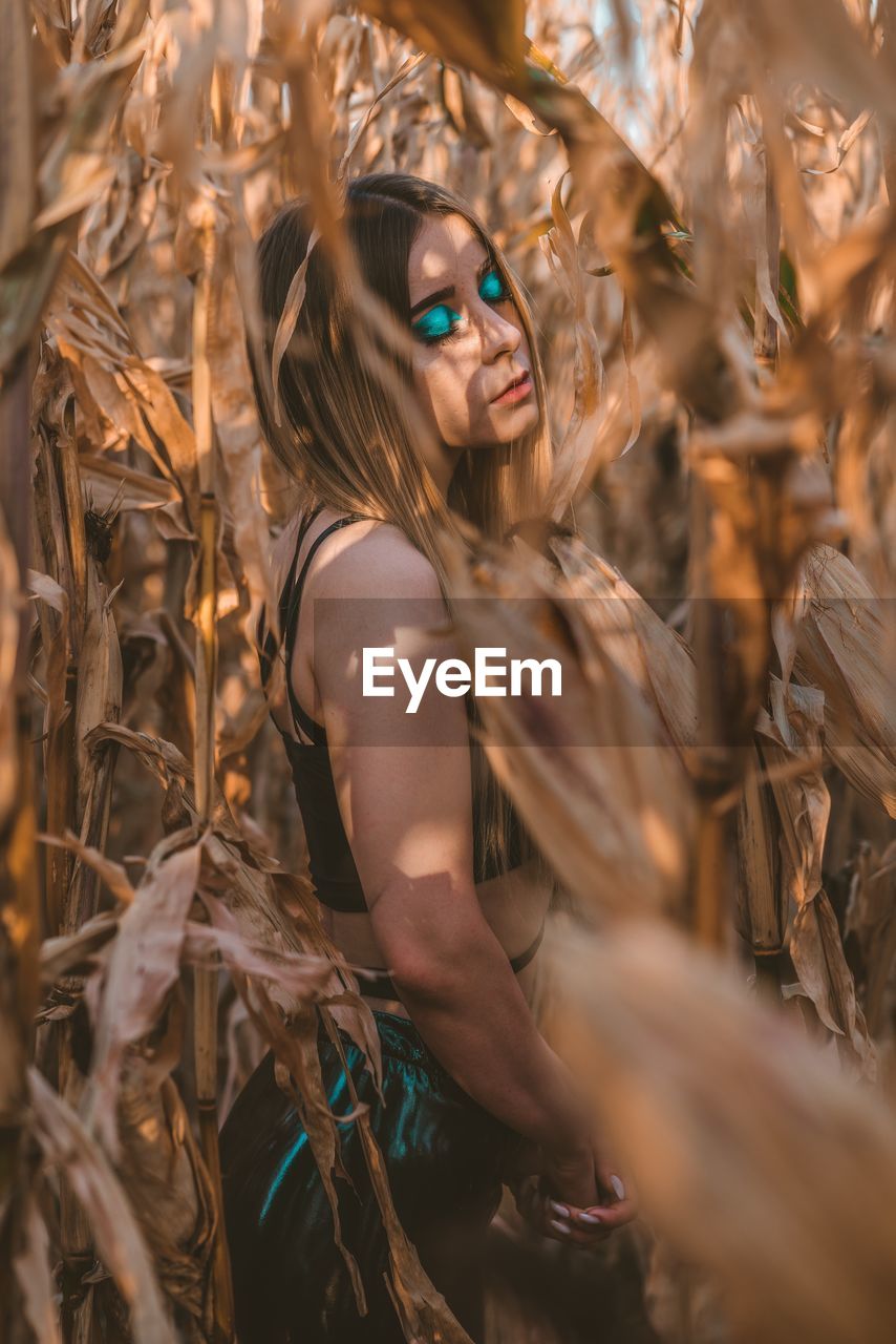 Young woman standing amidst plants