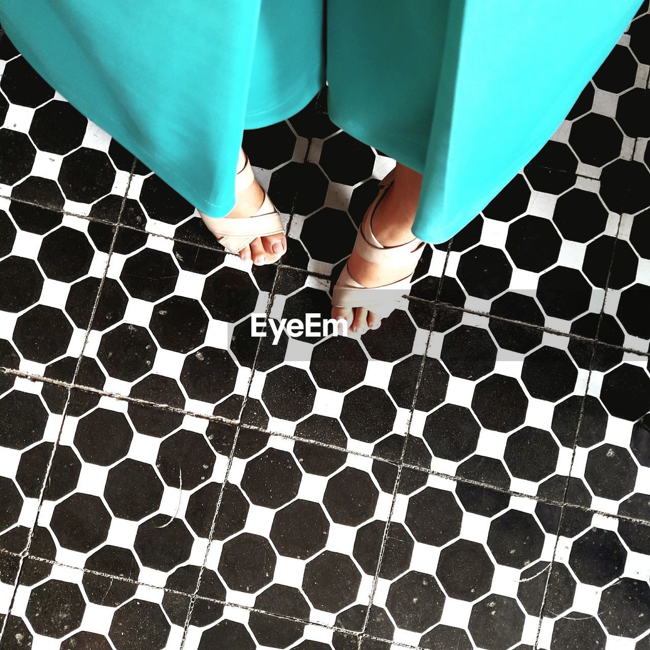 Low section of woman standing on patterned floor