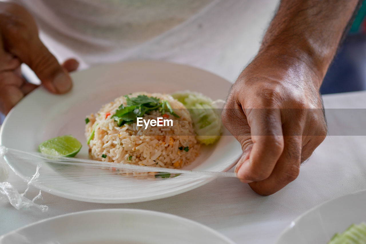 MIDSECTION OF MAN HOLDING FOOD IN PLATE