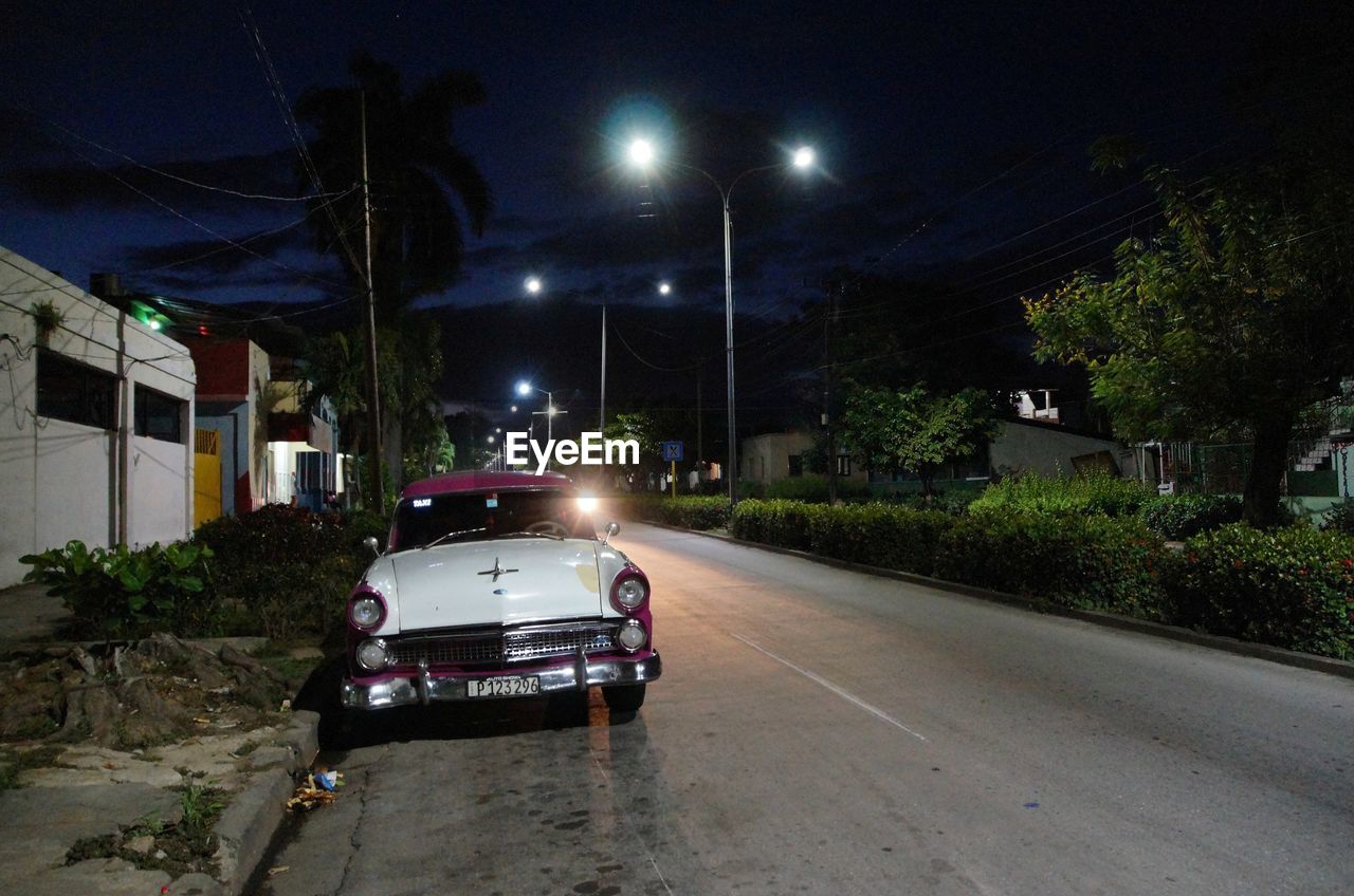 VIEW OF ILLUMINATED STREET AT NIGHT