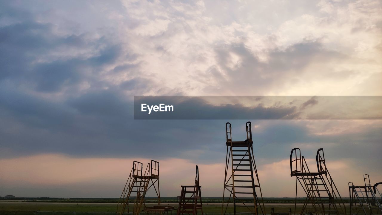 LOW ANGLE VIEW OF CRANE ON FIELD AGAINST SKY