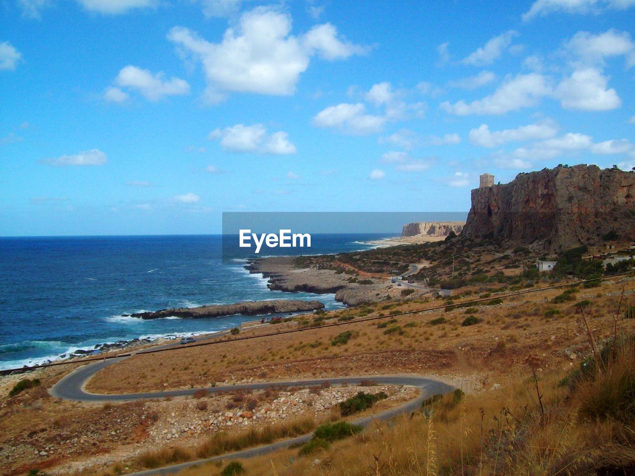 View of calm beach against blue sky