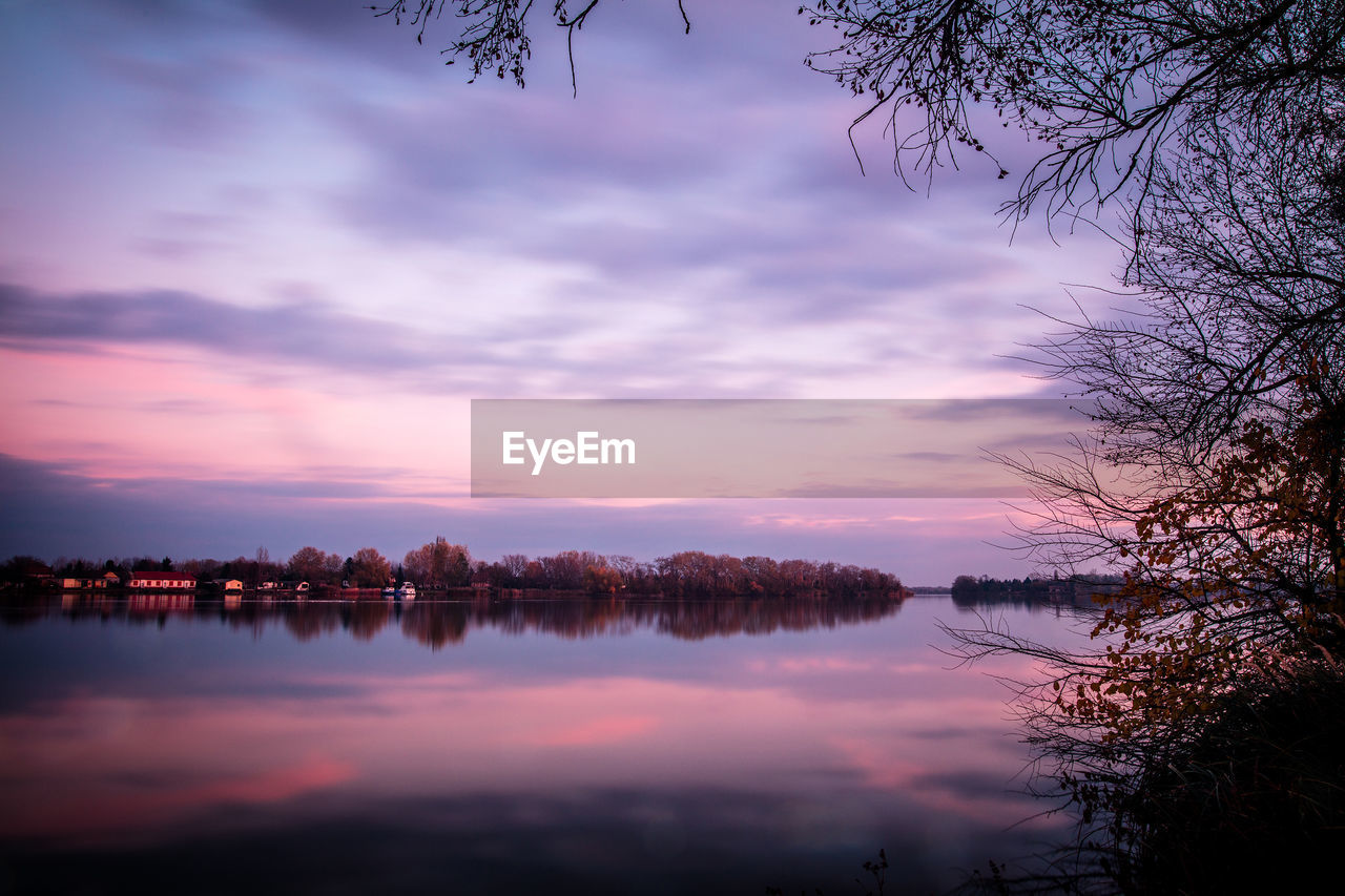 Scenic view of lake against sky at sunset