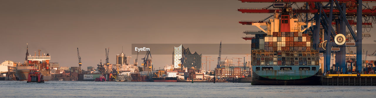 COMMERCIAL DOCK BY SEA AGAINST SKY IN CITY