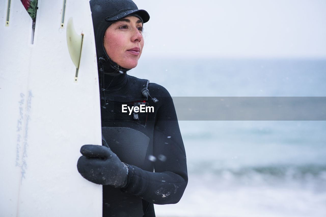 Young woman going winter surfing in snow