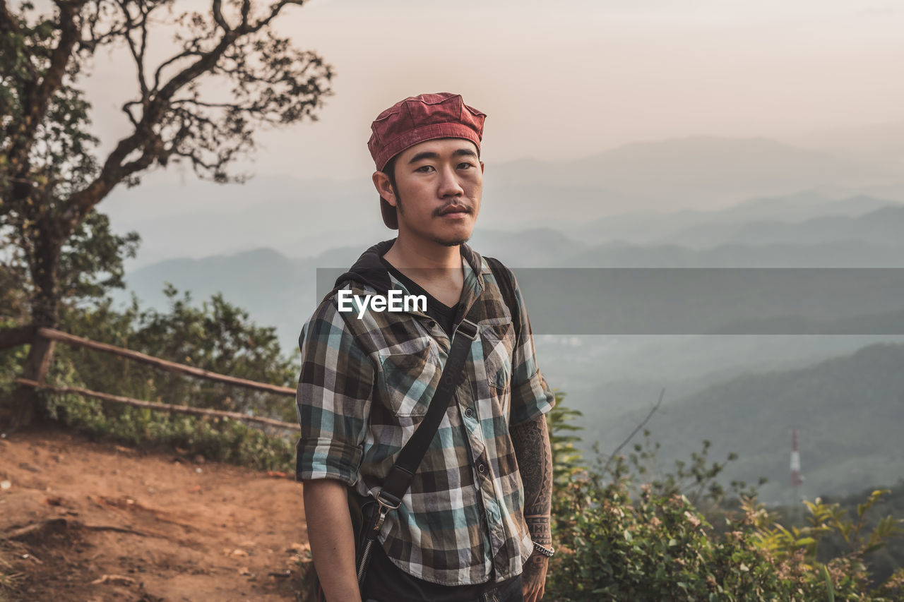 Portrait of young man standing on mountain