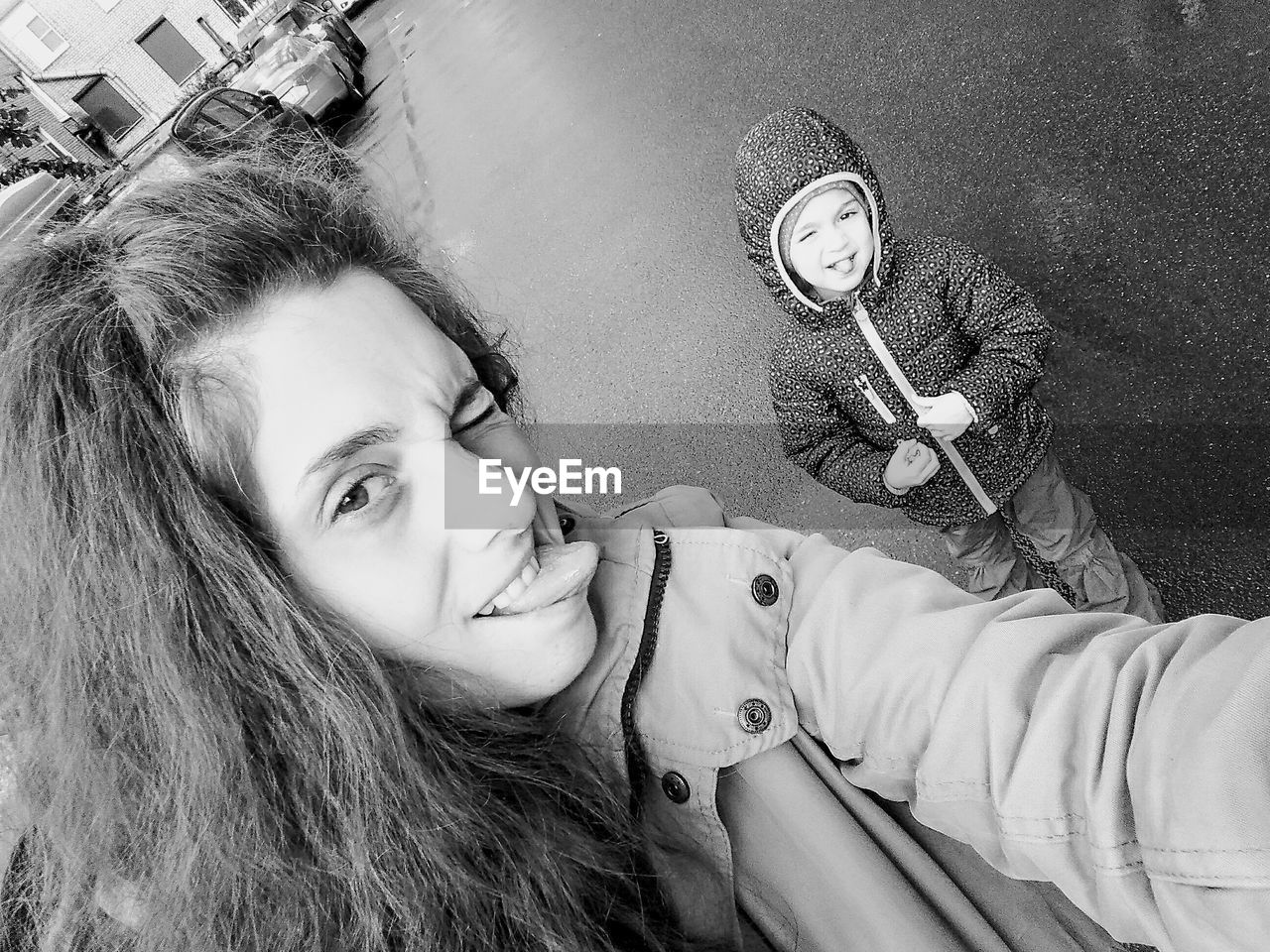 Portrait of young woman with daughter standing on road