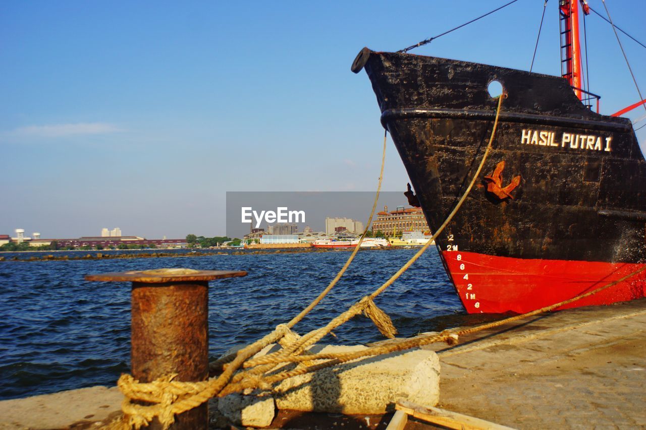 BOAT MOORED IN SEA AGAINST SKY