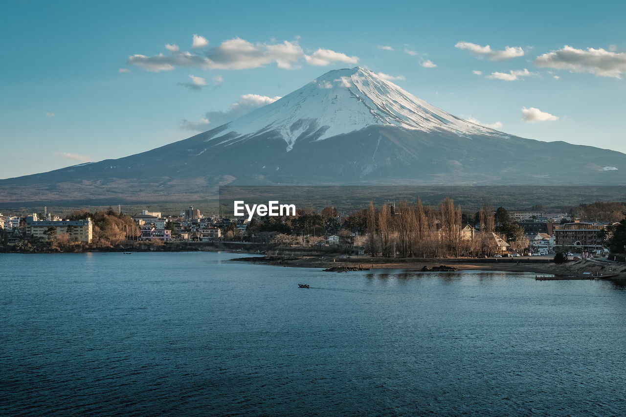 Scenic view of lake by snowcapped mountain against sky