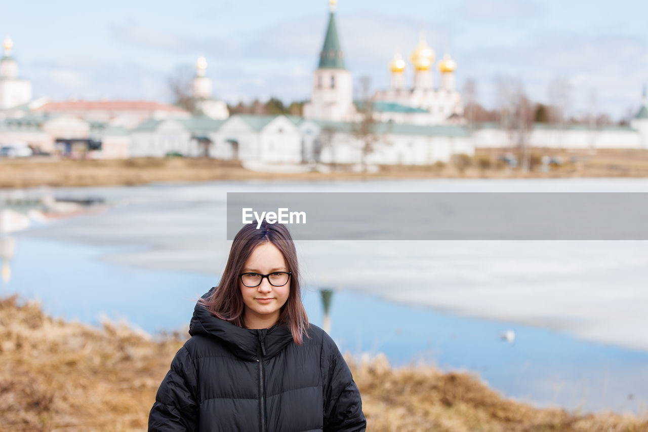 Portrait of a girl, a teenager against the background of ancient sights and a spring 