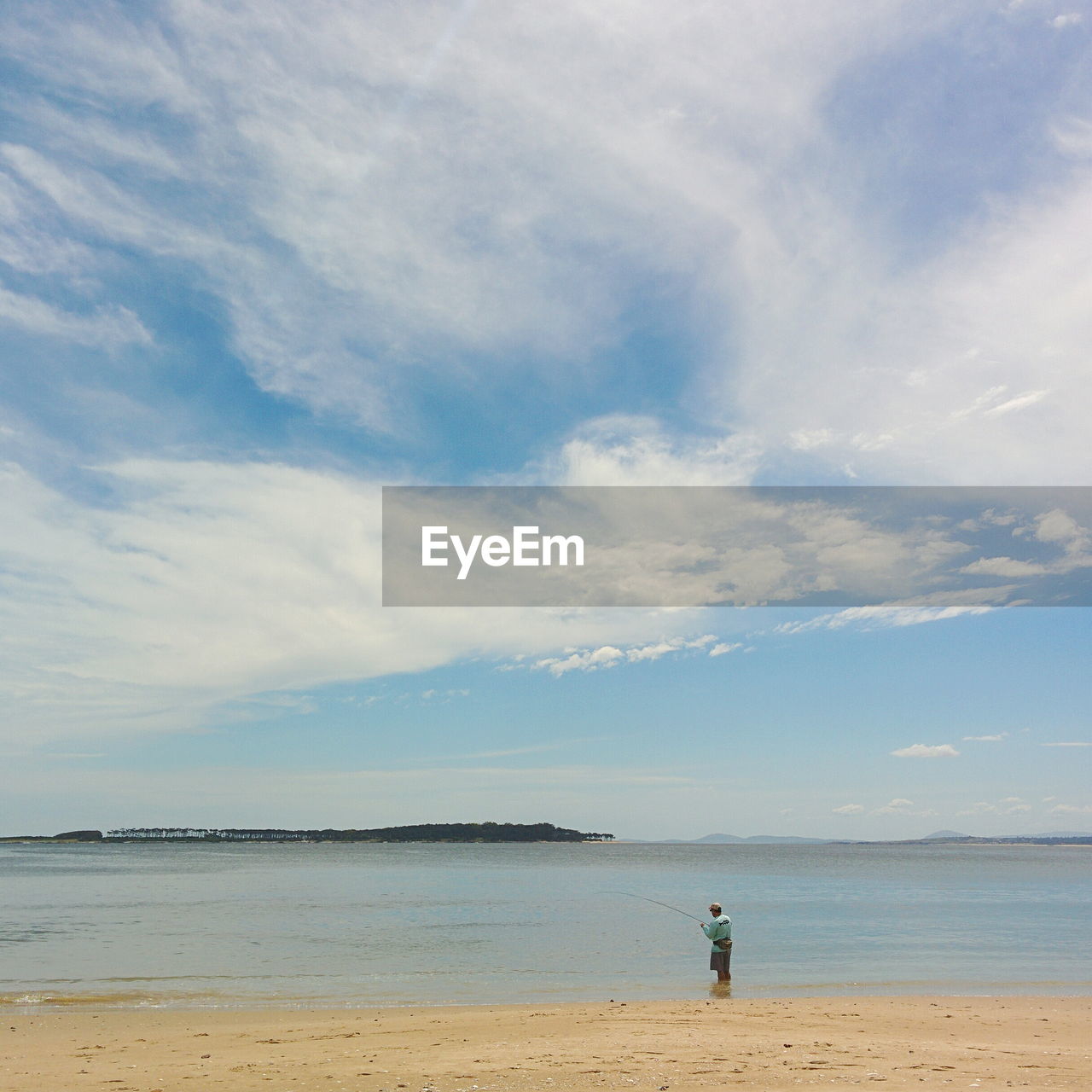 MAN STANDING AT BEACH AGAINST SKY