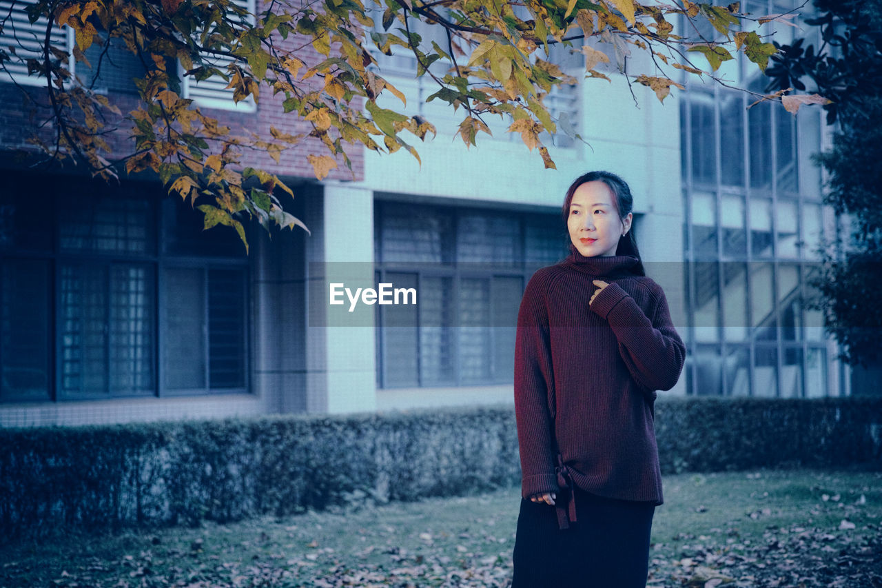 Woman standing against building