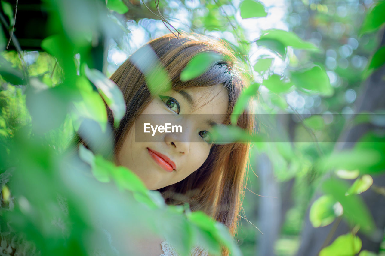 Portrait of woman seen through plant